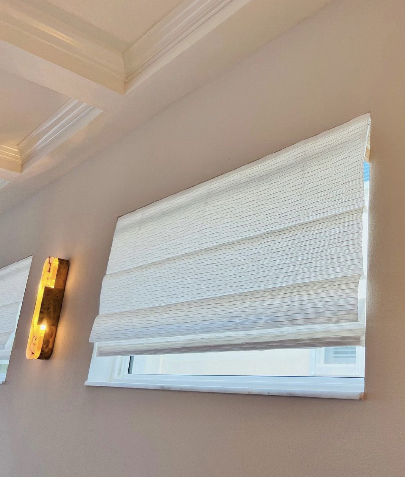 Row of tailored Roman shades along a hallway